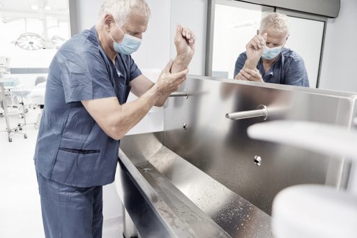 Chirurg beim chirurgischen Händewaschen mit Desinfektion vor einer Operation